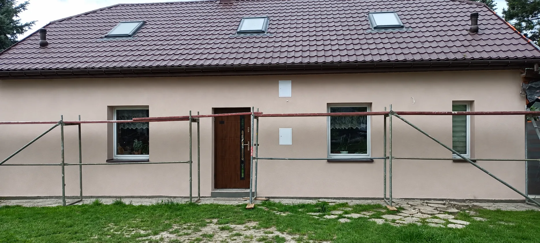 Dach domu z pokryciem z blachodachówki i oknami dachowymi