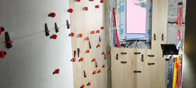 Układanie płytek ceramicznych przy oknie w łazience